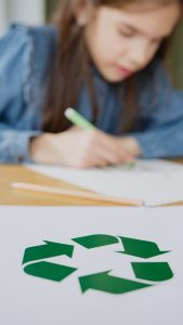 Girl drawing a recycling symbol